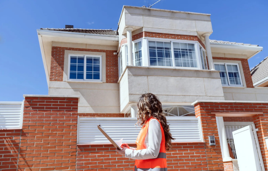 INSPECTION LOS ANGELES female inspector evaluating front of brick house